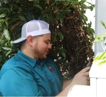 A Willard technician in a teal shirt and white cap looks down.