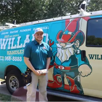 A smiling Willard technician stands by a company service van.