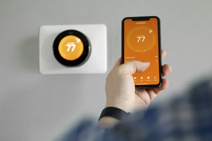 Thermostat being controlled by a smart phone app. Thermostat being controlled by a smart phone app.