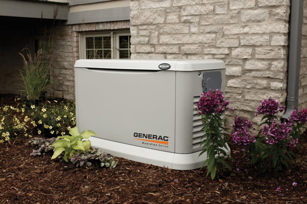 Generac generator outside of a home, surrounded by flowers and plants.
