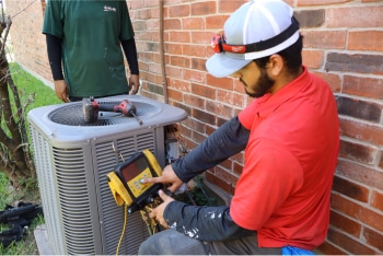 Two Willard technicians service an outdoor AC unit.