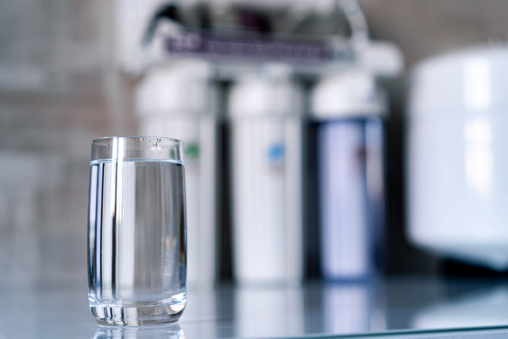 Pure water in glass and water filters on the blurred background