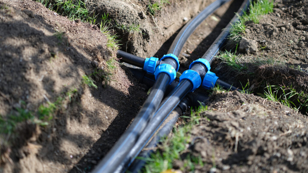 Installed PVC water lines in a trench in a home's yard.